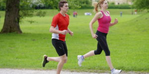 Young couple jogging in park at morning. Health and fitness.